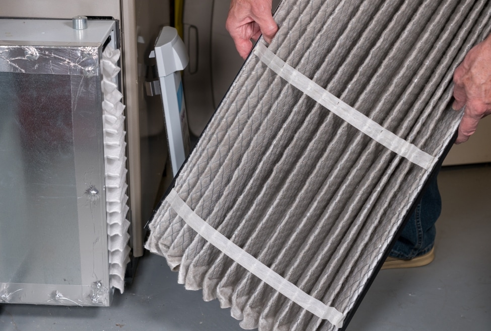 Professional technician inspecting a dirty air filter in a home HVAC furnace system, addressing common heating problems. Contact Arctic Air for HVAC services today! Keywords: heating problems, HVAC furnace, dirty air filter, furnace repair near me, heater repair near me, heating repair near me, heat pump repair near me, professional technician, home HVAC system, Furnace Repair Palmdale, Heating Repair Palmdale, Furnace Repair Lancaster, Heating Repair Lancaster, Furnace Repair Quartz Hill, Heating Repair Quartz Hill, Furnace Repair Rosamond, Heating Repair Rosamond, Furnace Repair Acton, Heating Repair Acton, Furnace Repair Tehachapi, Heating Repair Tehachapi, Furnace Repair Littlerock, Heating Repair Littlerock, Furnace Repair Mojave, Heating Repair Mojave.